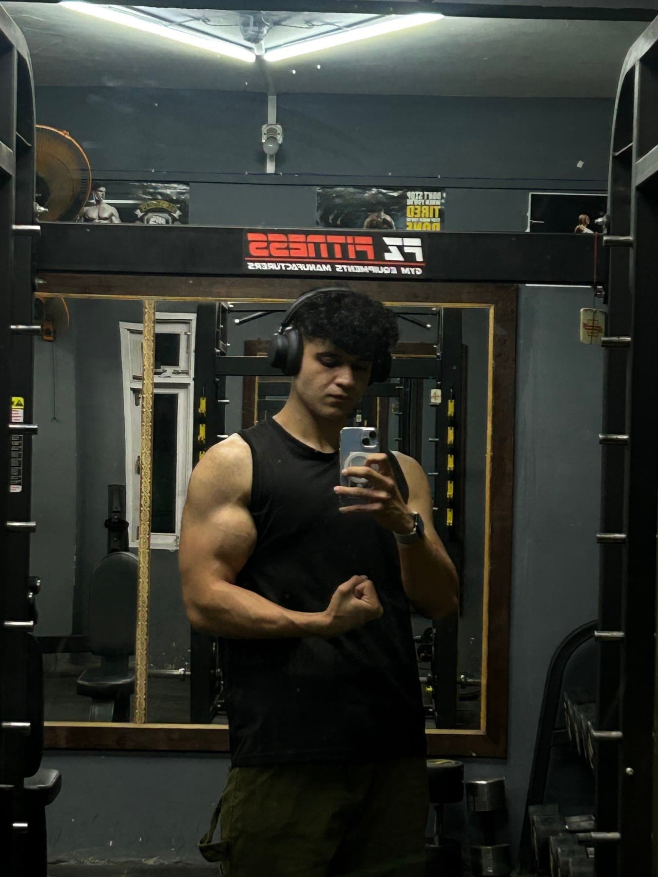 Siddharth in the gym, mirror selfie with headphones on