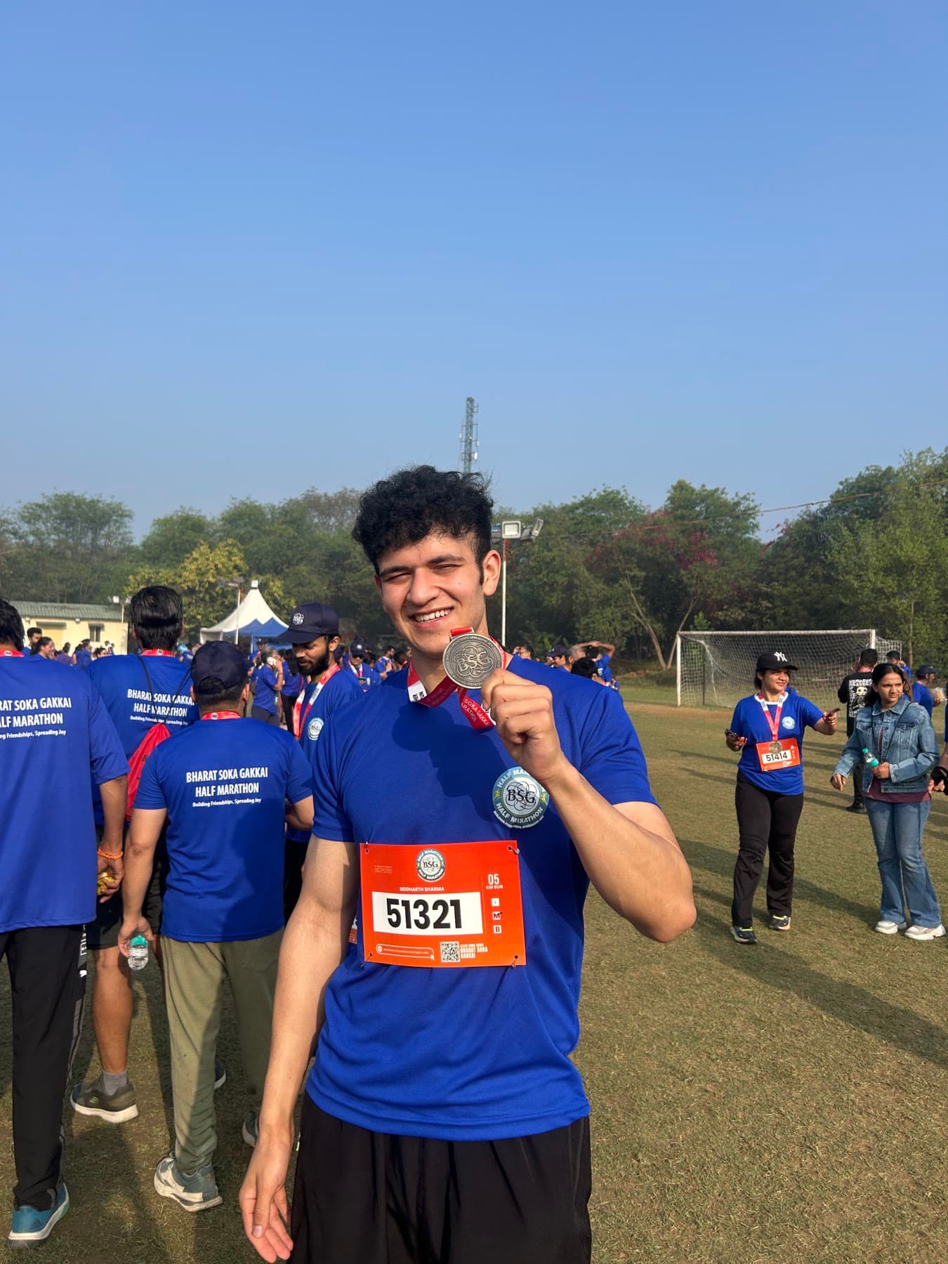 Siddharth holding up a half-marathon finisher's medal